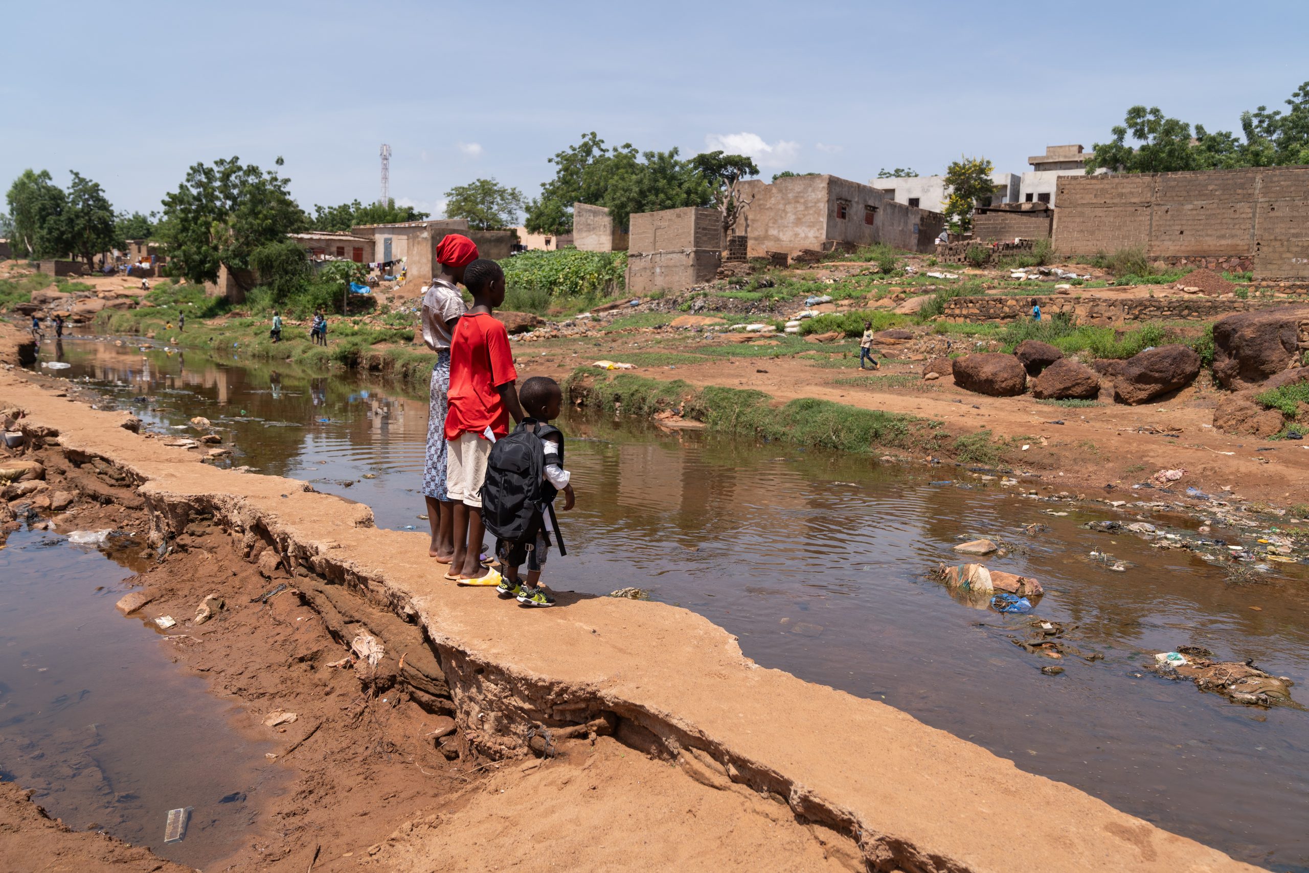 Group of African Village children looking desolately at the road washed away by the flood after heavy rainstorms, concept of global warming and climte change